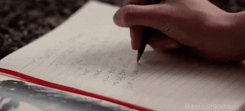 hand writing something on the paper