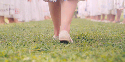 girl walking through grass
